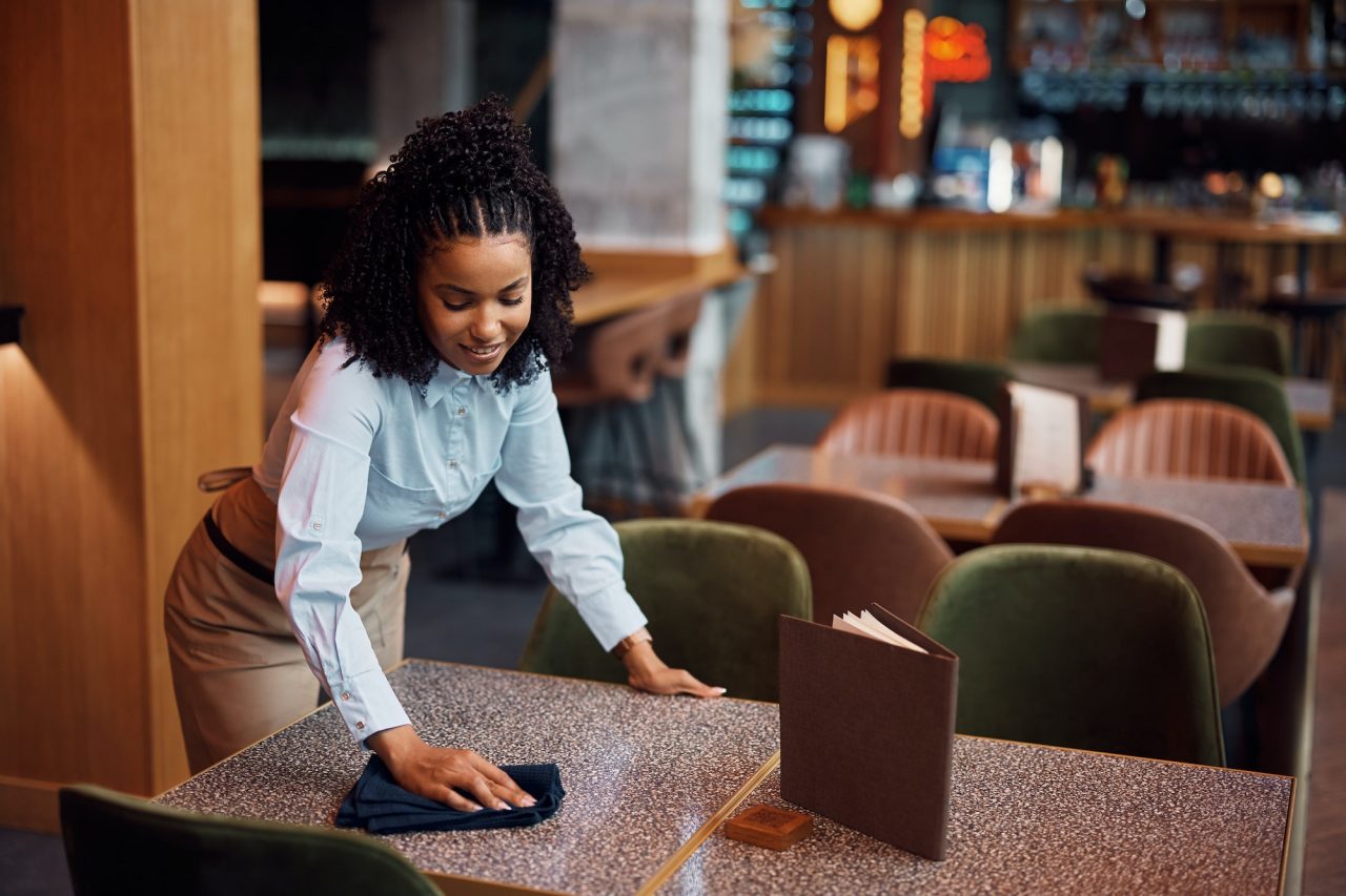 happy-african-american-waitress-cleaning-tables-in-a-cafe-.jpg